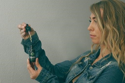 woman holding hemp oil bottle
