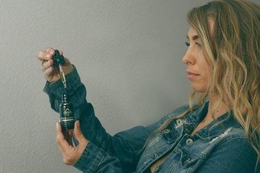 A woman holding a bottle of hemp oil