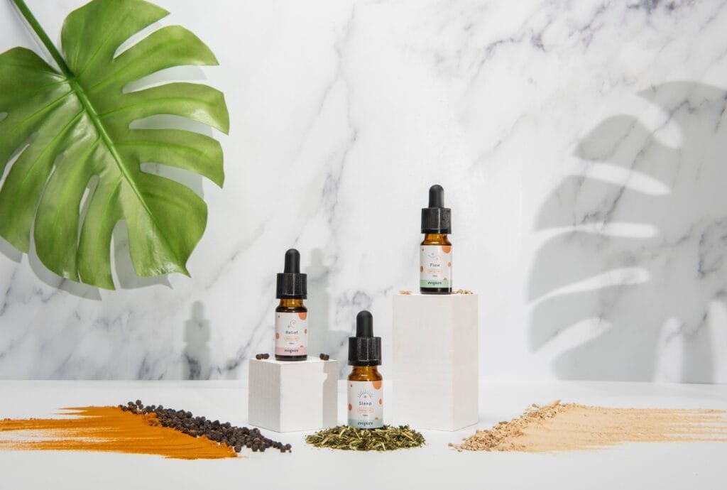 three bottles of cbd oil on a white table