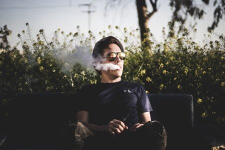 man sitting on bench vaping