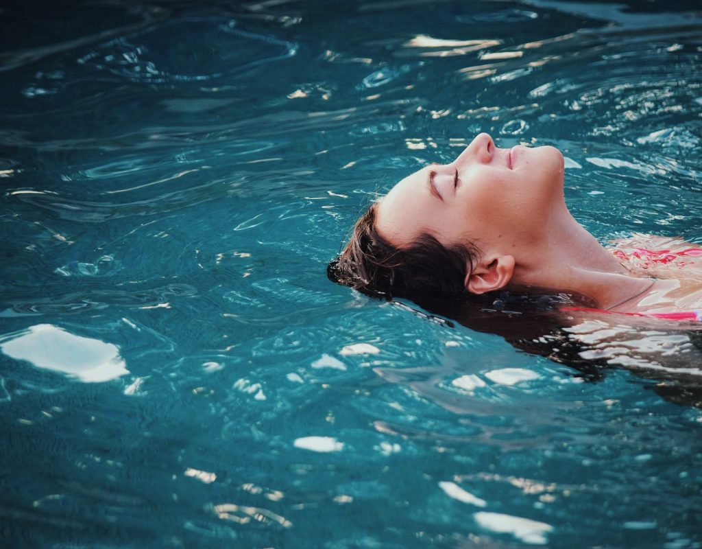 female in pool floating on back