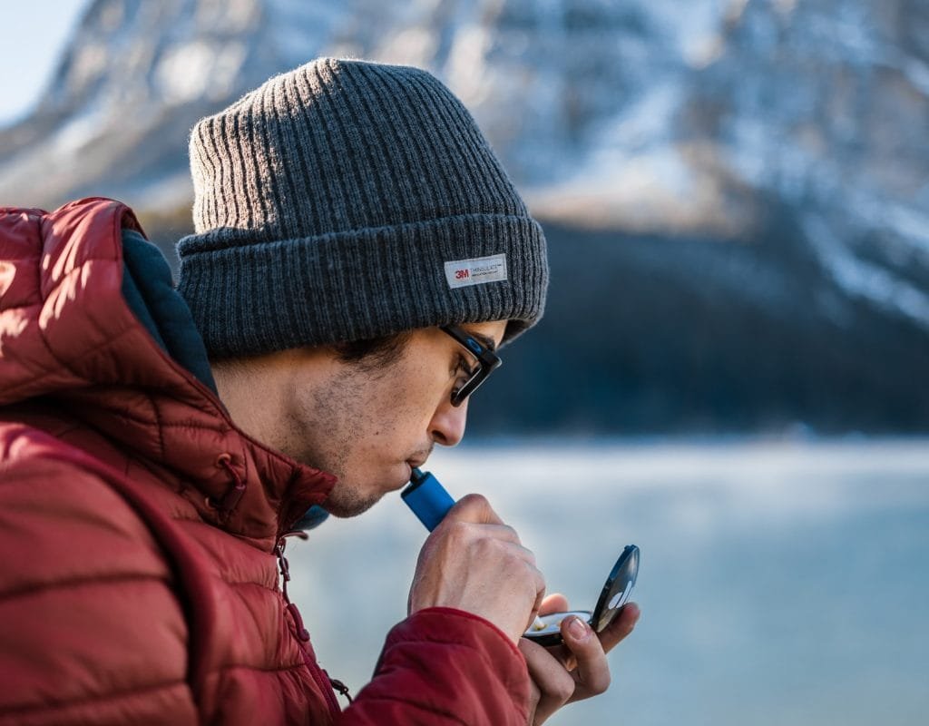 male using a electric dab pen to inhale concentrate