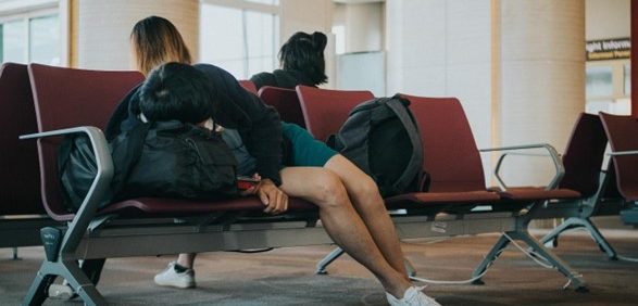 female sitting on bench in airport